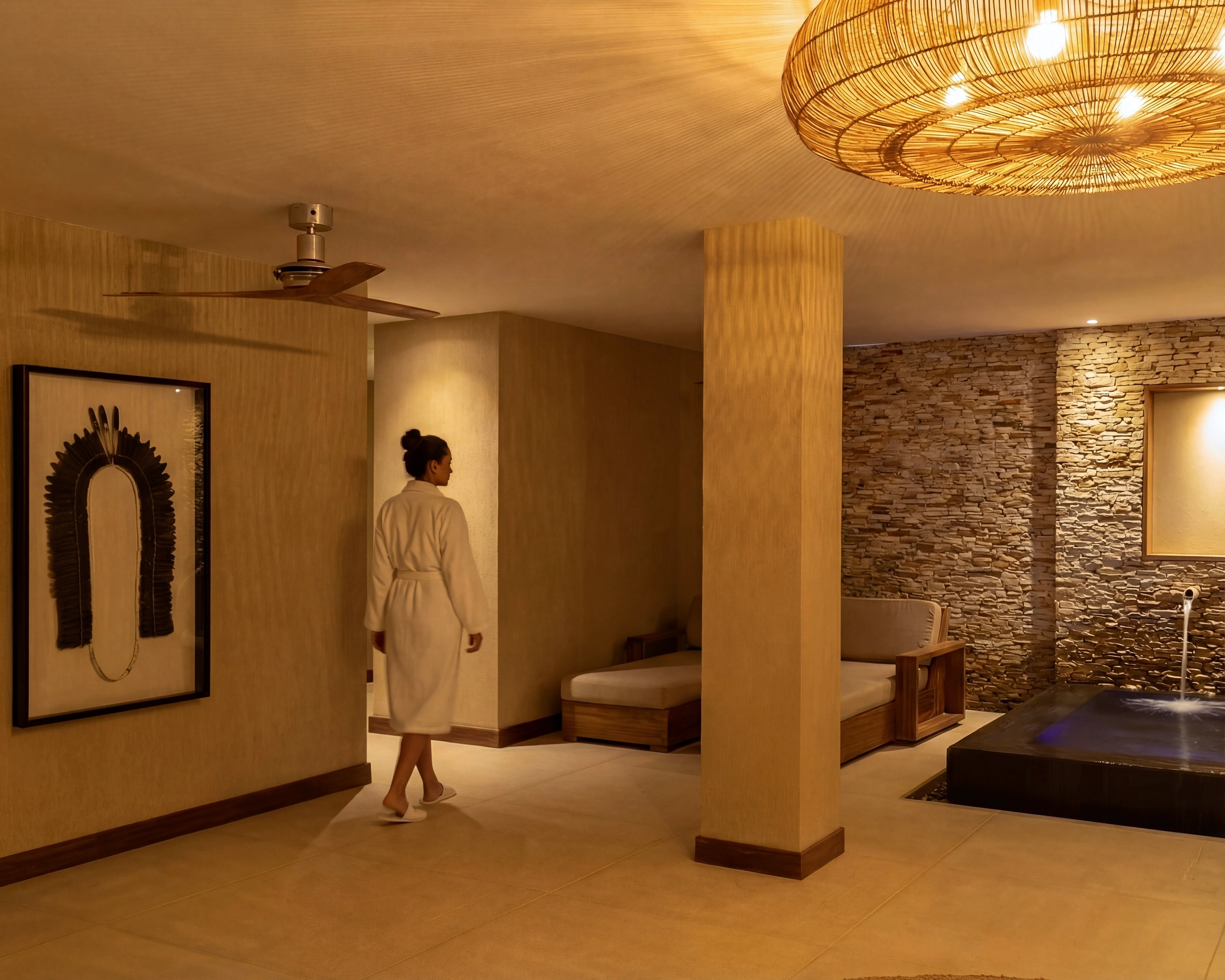 Sala de spa com parede de pedra empilhada e materiais naturais, luz quente.